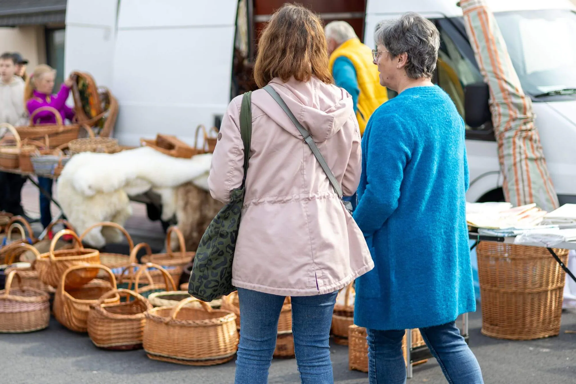 Zwei Besucherinnen an einem Stand mit geflochtenen Körben